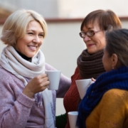 Group of smiling mature women drinking tea at balcony