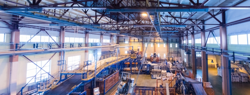 Factory workshop interior and machines on glass production background